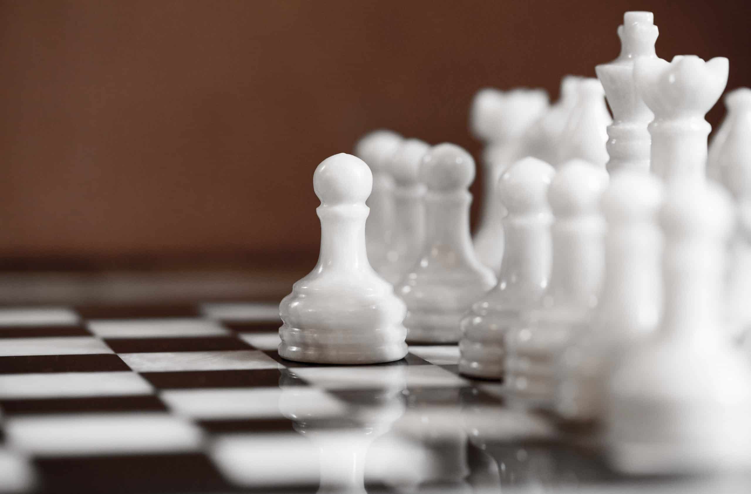 Selected focused chess set. White go the first, pawn moves one step forward. The central figure-pawn is on focused. Teamwork concept. Chess game.